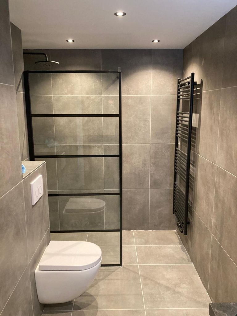 Badkamer met inloopdouche, zwarte glaswand en hangtoilet